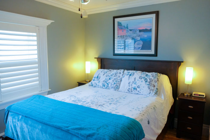 image: interior guest room queen bed with blue covers
